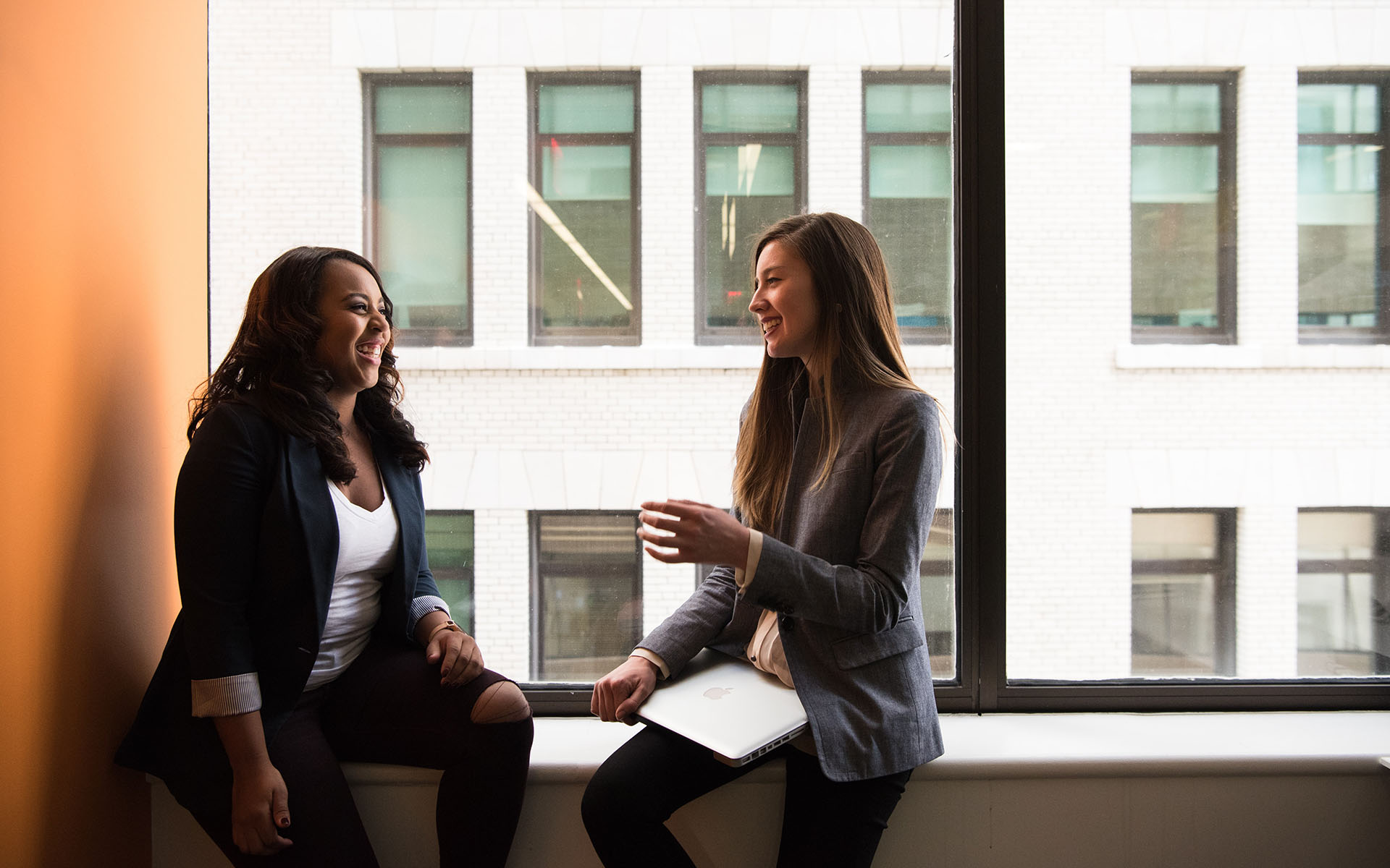 Women having a conversation in front of window
