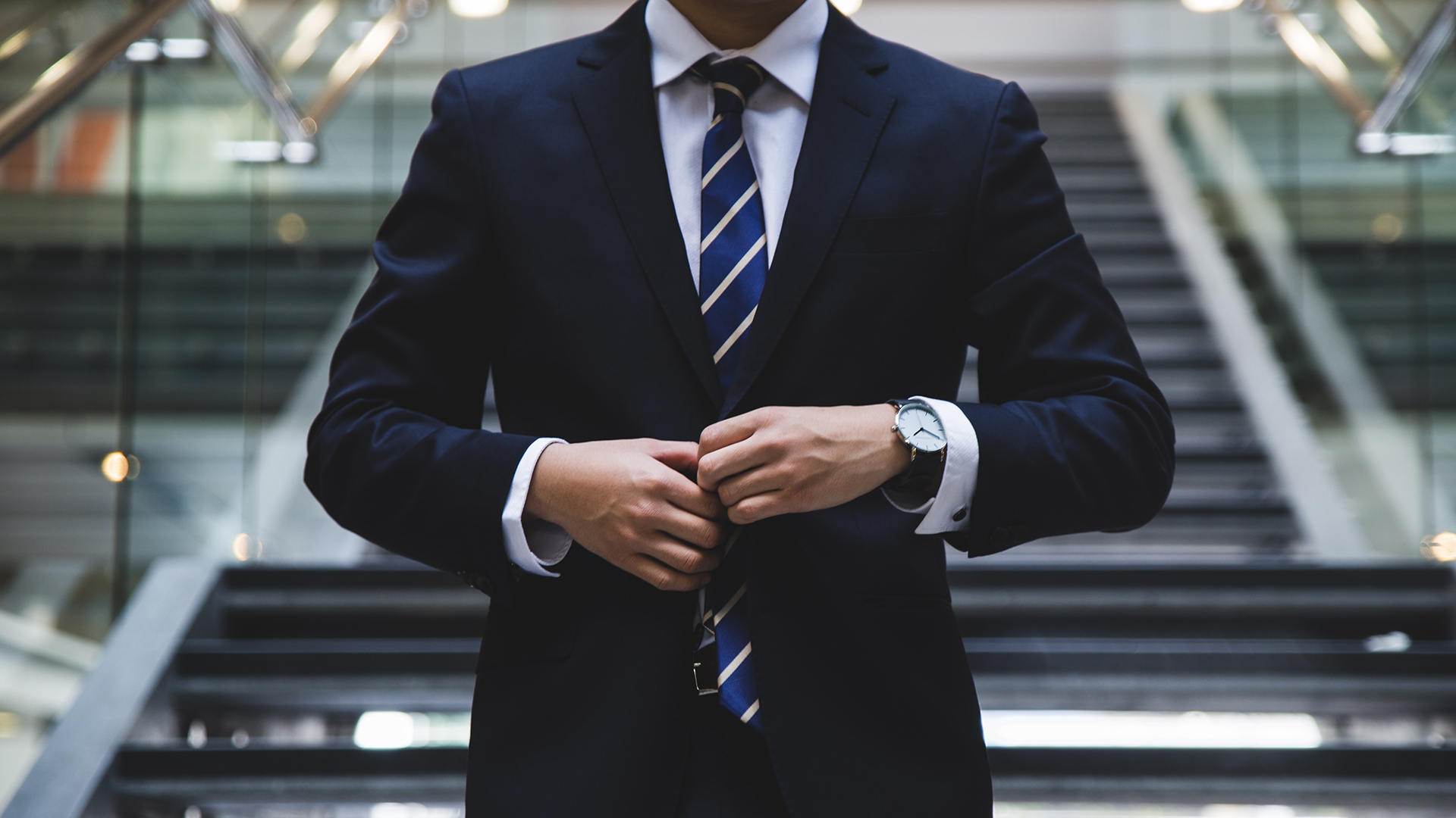 A man buttoning his suit jacket