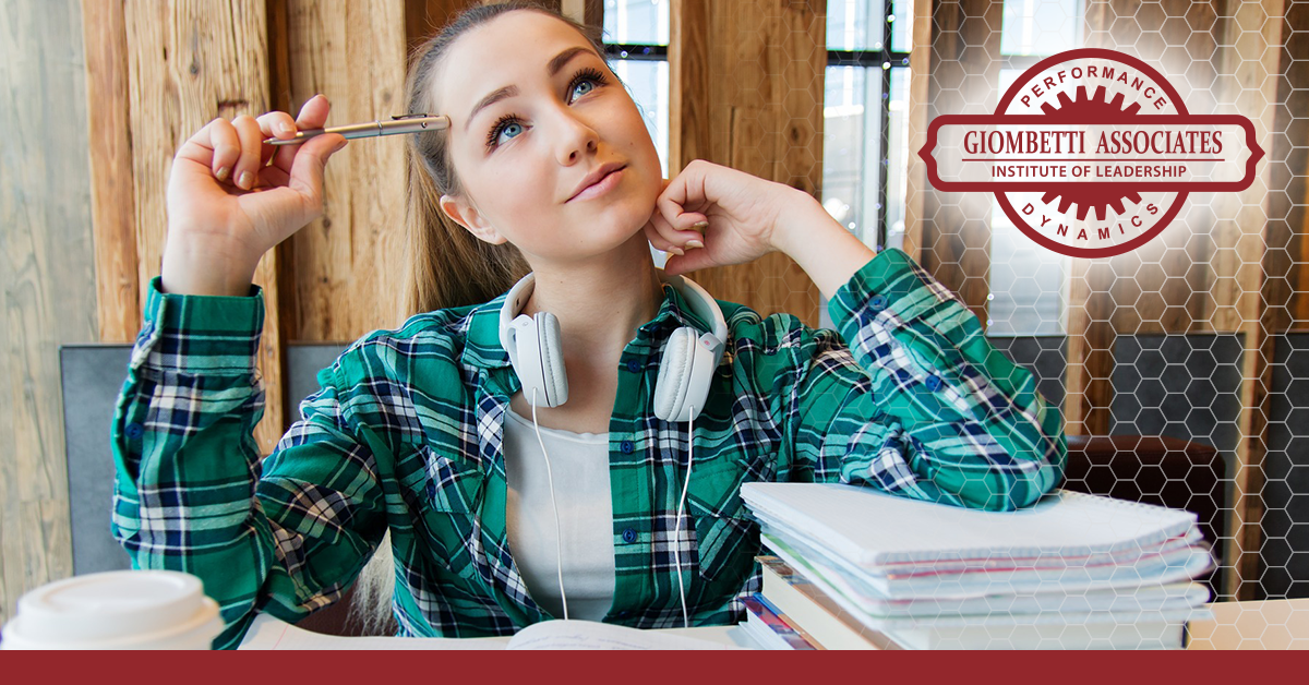 student thinking with arm on a stack on notebooks