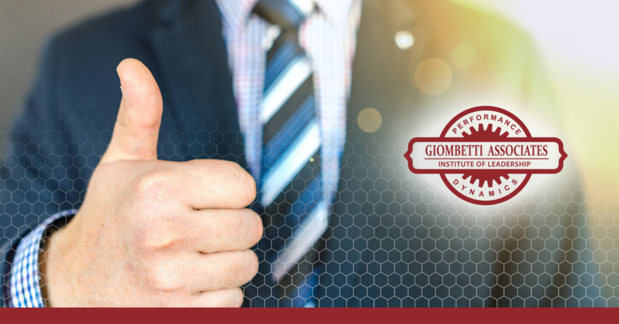 Picture of a man in a suit giving a nice thumbs up sign for blog on National Compliment Day